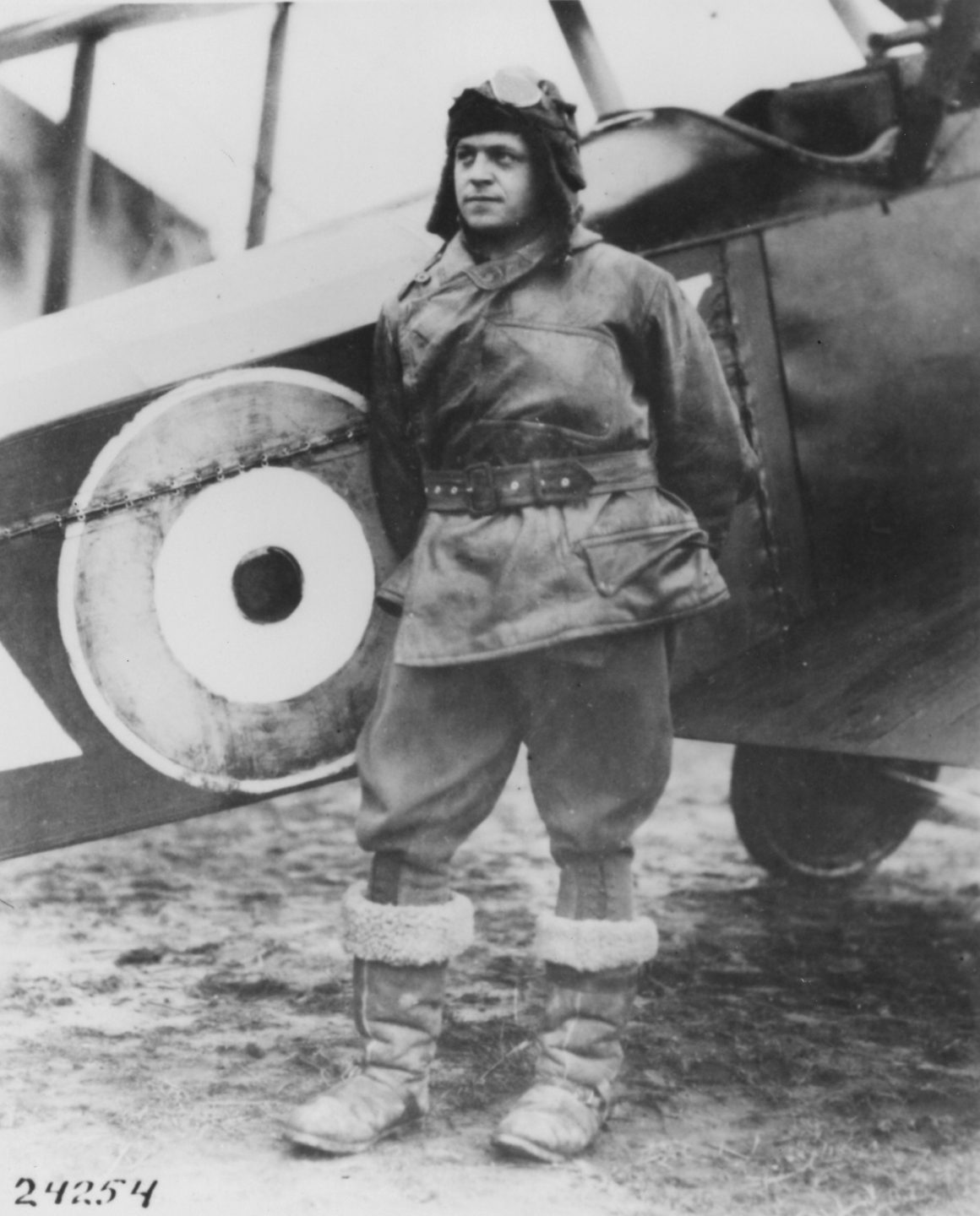 Lt. Orville A. Ralston in France beside a fighter plane painted with the roundel of the Royal Air Force.