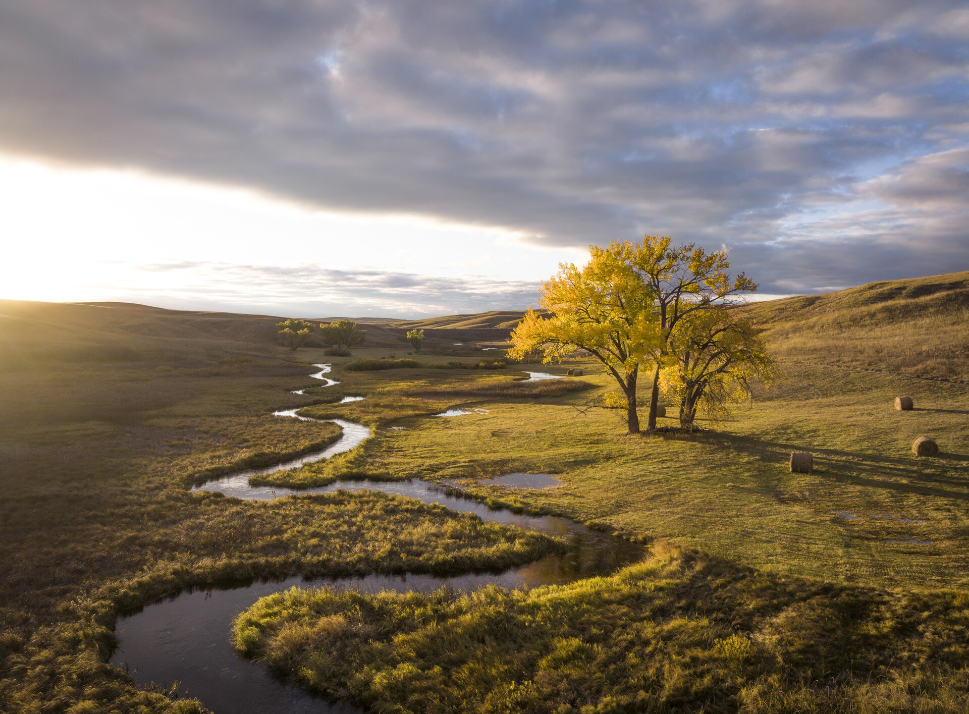 A creek winding through a prairie in autumn.