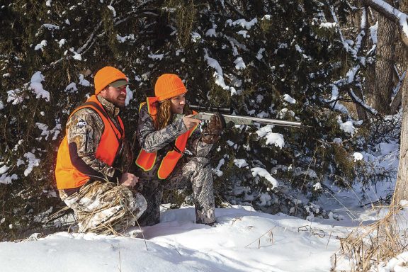 Man and woman hunting in the snow during the December muzzleloader season.