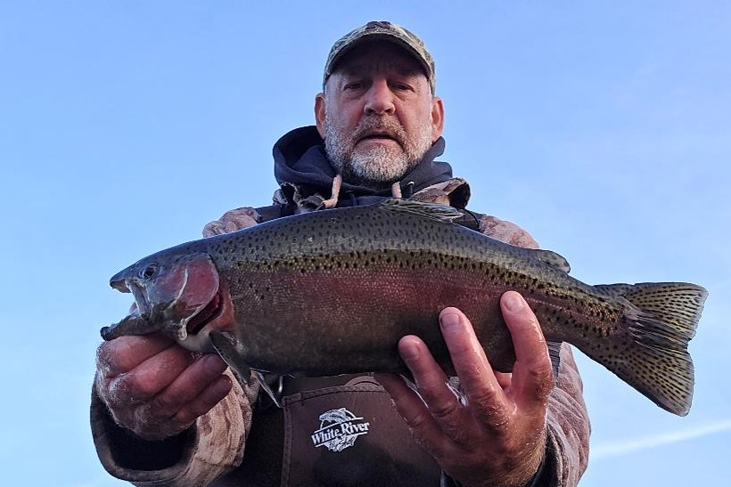 Angler holding rainbow trout.