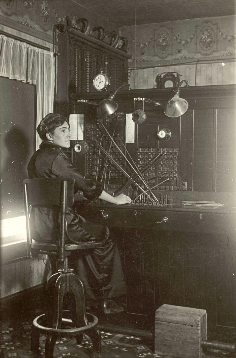 Black and white photo of a woman working a telephone switchboard.