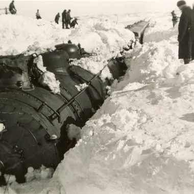 Train buried in snow during blizzard.