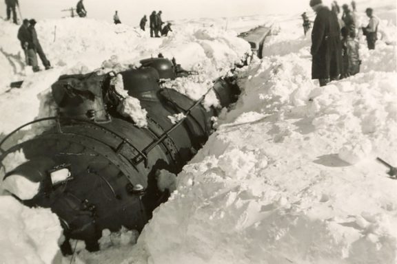 Train buried in snow during blizzard.