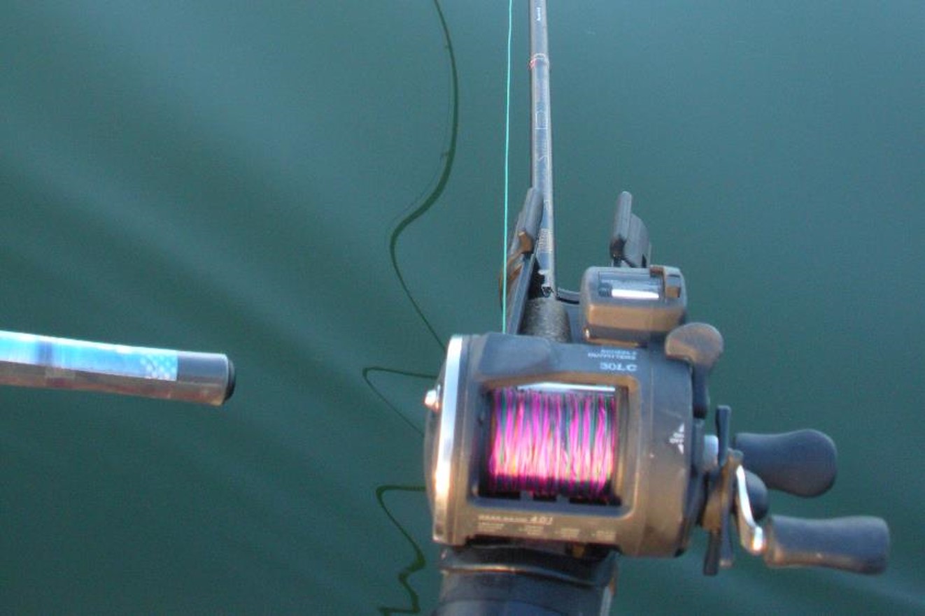 Fishing rod and reel in a rod holder on side of boat.