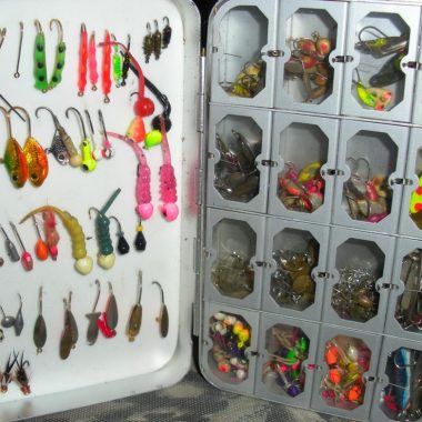 Tackle box full of ice fishing jigs.