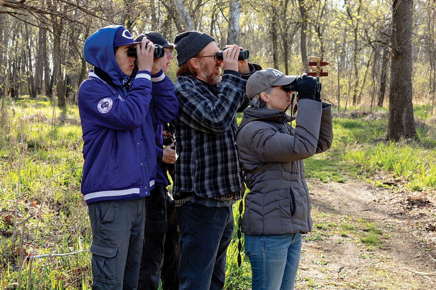 Silas, Eli, Corey and Andi Weber watch a bird in the woodlands at Fontenelle Forest in Bellevue last spring.