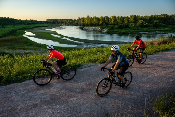Two man and a woman bicycling on the Cowboy Trail near Norfolk.