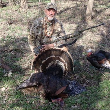 Hunter posing with turkey gobbler.