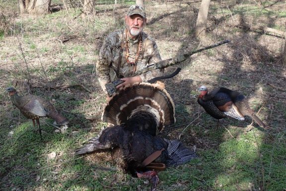 Hunter posing with turkey gobbler.