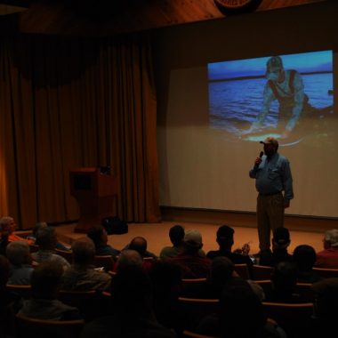Speaker standing in front of an audience.