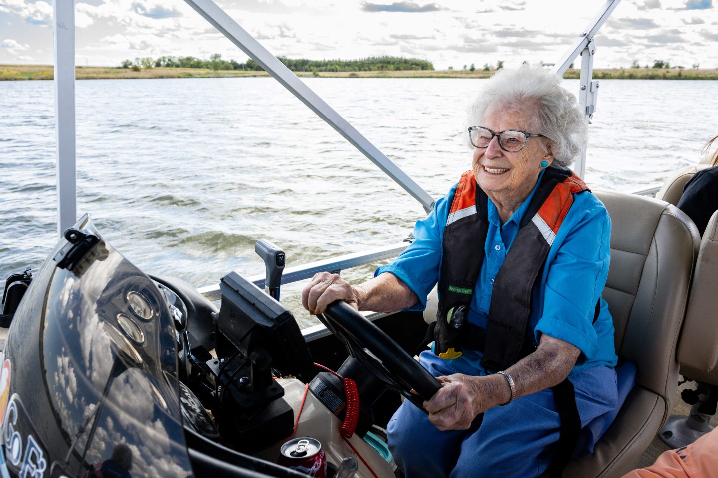 Shirley Schoenrock, a resident at Saunders Medical Center, smiles as she drives the Live Well. Go Fish. boat on Lake Wanahoo.