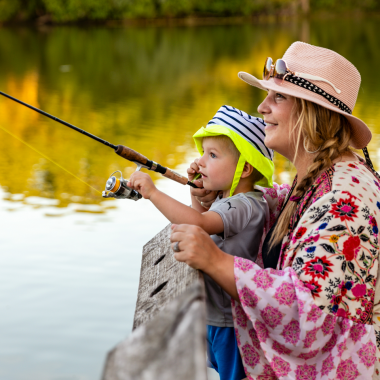 A mother and young son fish off a fishing pier.