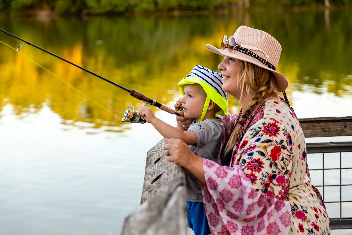 A mother and young son fish off a fishing pier.