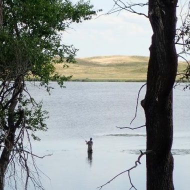 Wading angler on a Nebraska sandhills lake.