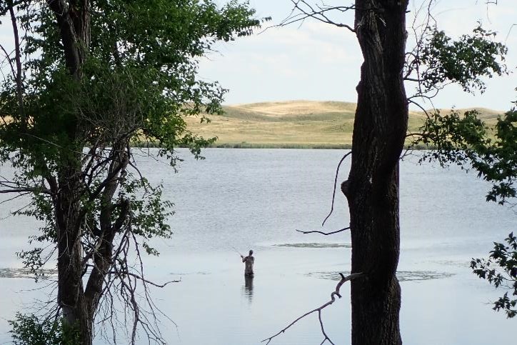 Wading angler on a Nebraska sandhills lake.
