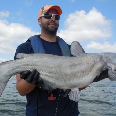 Biologist holding catfish.