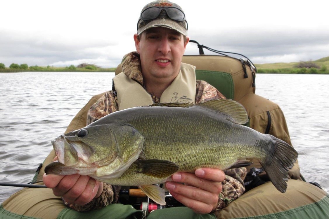 Angler holding a largemouth bass.