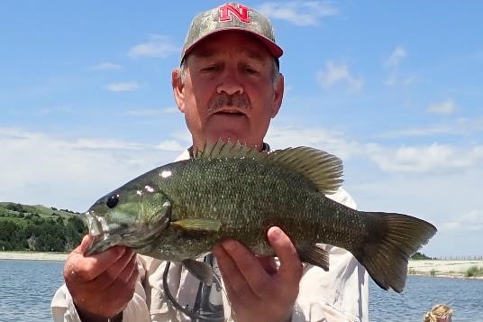 Angler holding a smallmouth bass.