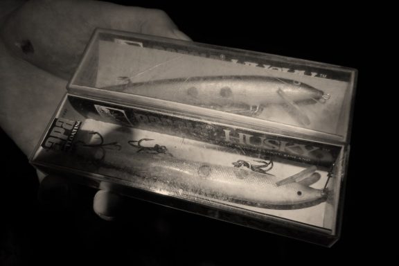 Angler holding two boxed fishing lures. Photo by Daryl Bauer, Nebraska Game & Parks Commission.