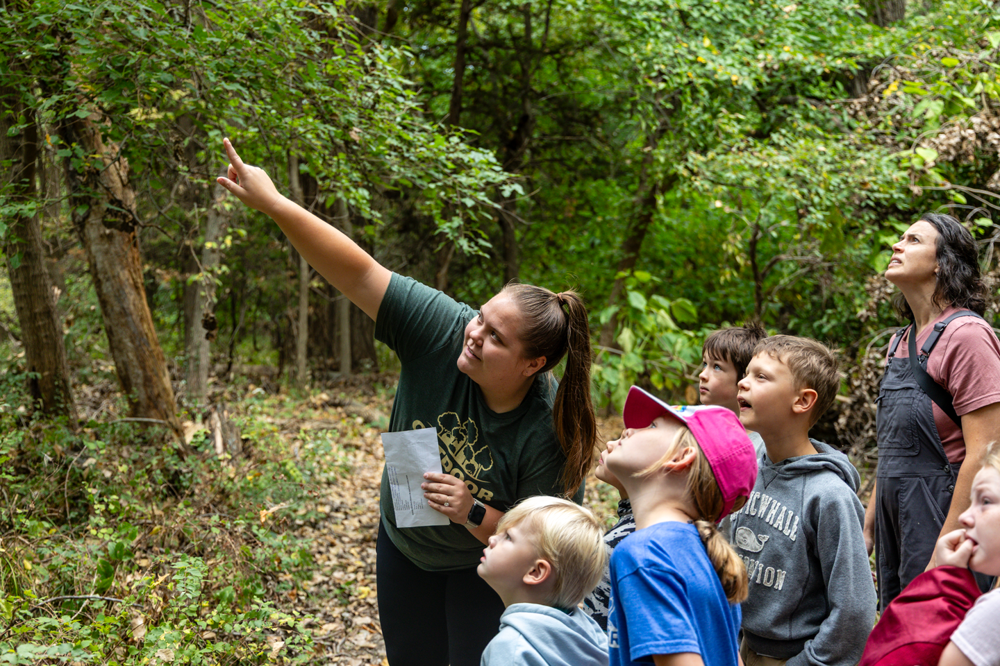 Naturalist Alena Carlson points at a bird during a Homeschool Hike at Schramm Park State Recreation Area.