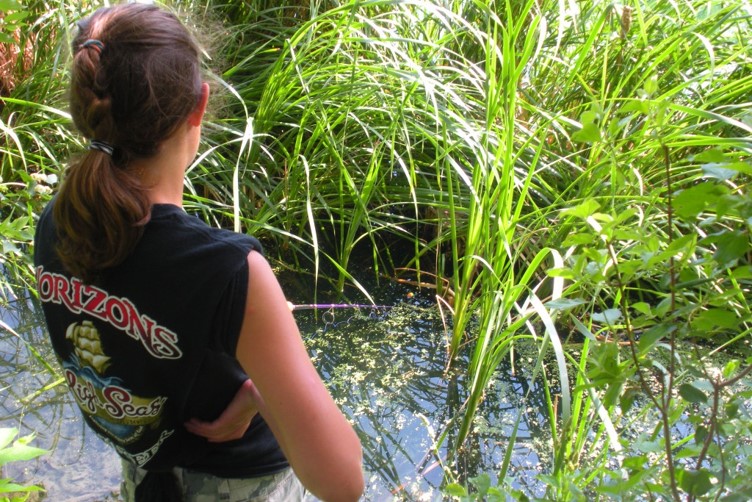 Girl fishing in vegetation near shore.  Photo by Daryl Bauer, Nebraska Game & Parks Commission.