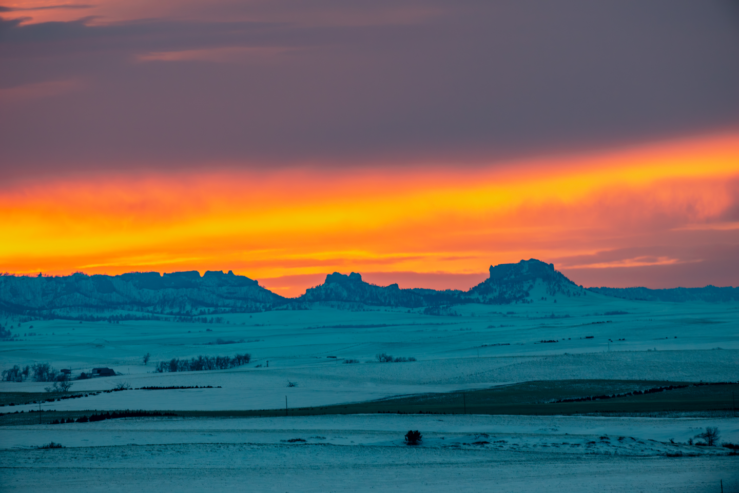 The sun sets behind Crow Butte, at right, and Little Crow Butte, ending a winter day.