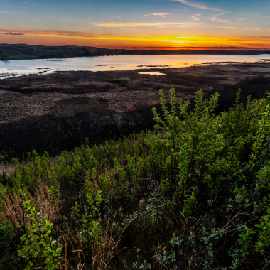 The sun rises behind Steverson Lake, which has the most surface area of the property’s three lakes.