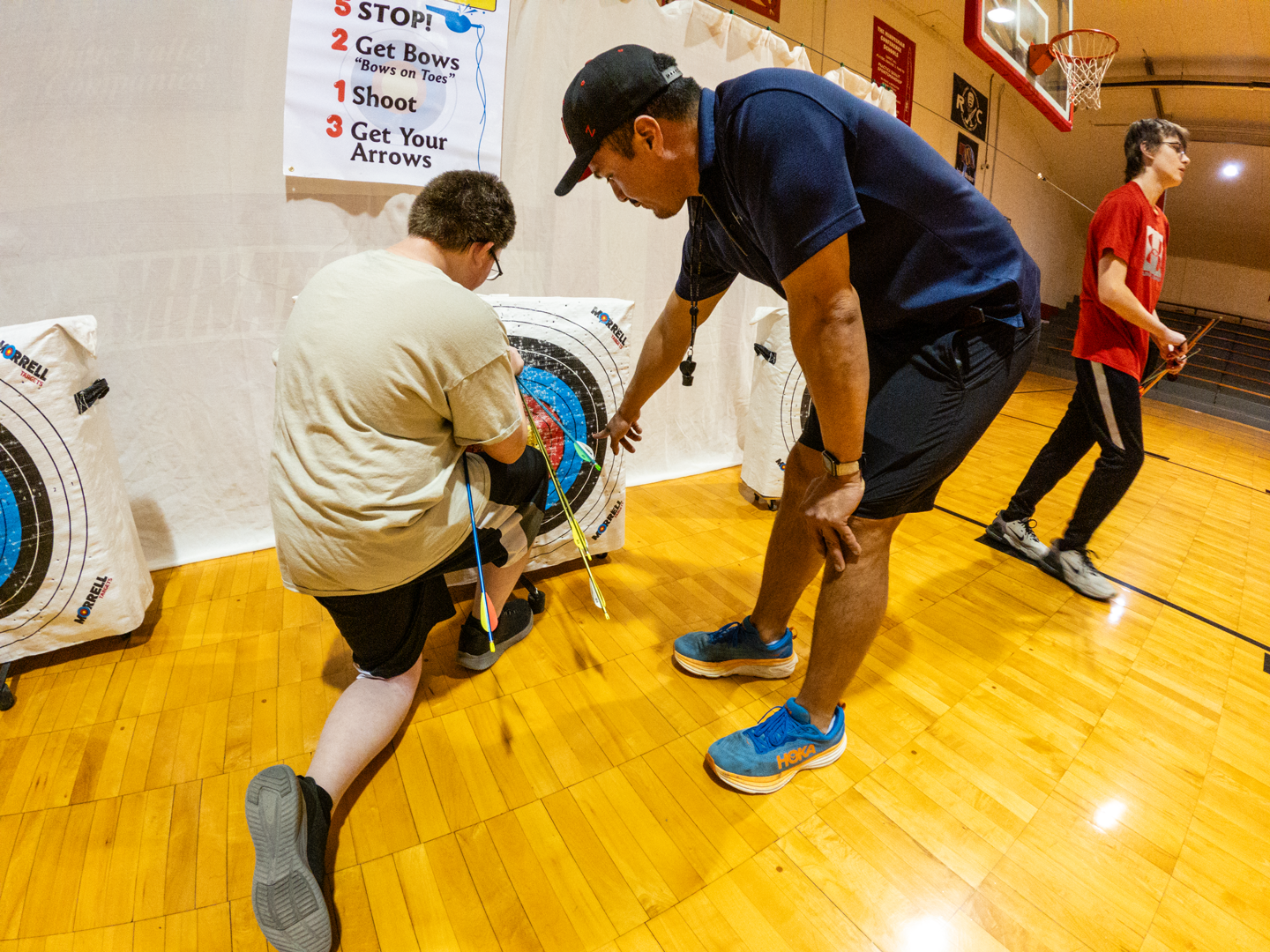 JJ Ozuna, PE teacher and NASP Coach at Minatare High School, one of the smaller schools involved in the program, helps Jericho Timmens score his target during practice. If not for NASP, “Not a lot of kids are going to touch a bow,” Ozuna said. “It’s giving them a chance to be a part of that and introduce some skills.”