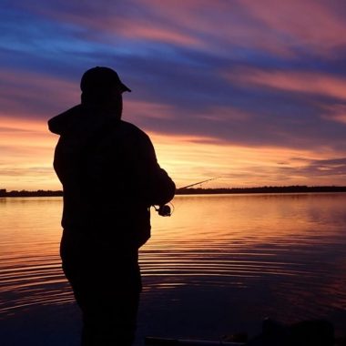 Silhouette of wading angler at sunset. Photo by Daryl Bauer, Nebraska Game & Parks Commission.