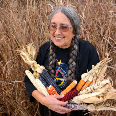 Deb Echo-Hawk of Pawnee, Oklahoma, founded the Pawnee Seed Preservation Society. She is carrying ancestral varieties of corn in her arms.