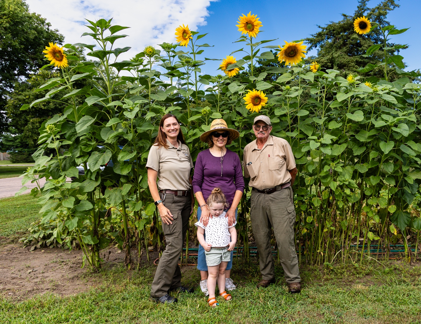 Regional Park Superintendent Laura Rose (left); gardener Ronnie O'Brien and her granddaughter, Louie Green, of Shelton; and Fort Kearny State Historical Park Superintendent Gene Hunt stand near Arikara sunflowers.
