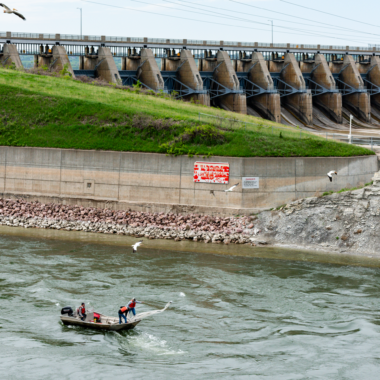 University of Nebraska-Lincoln graduate student Will Radigan pilots a boat as his assistants cast a trawl net to sample larval fish in the spillway below Gavins Point Dam.
