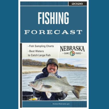 Cover of 2026 Nebraska Fishing Forecast. Fisheries biologist holding a hybrid striped bass. Photo by Nebraska Game & Parks Commission.