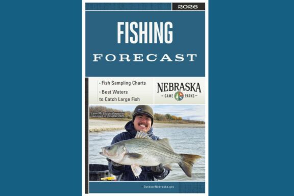 Cover of 2026 Nebraska Fishing Forecast. Fisheries biologist holding a hybrid striped bass. Photo by Nebraska Game & Parks Commission.