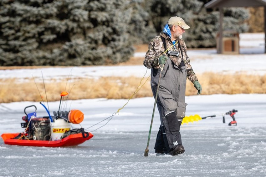 Angler walking on ice with spud bar.  Photo by Justin Haag, Nebraskaland Magazine.