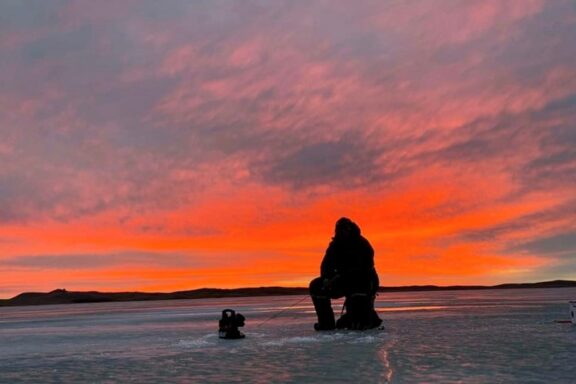 Ice angler silhouetted in sunset. Photo by Daniel Bauer.