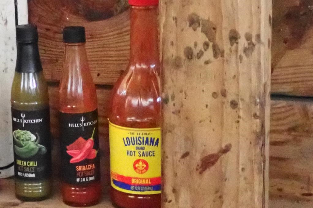 Hot sauce bottles lined up on waterfowl blind shelf. Photo by Daryl Bauer, Nebraska Game & Parks Commission.
