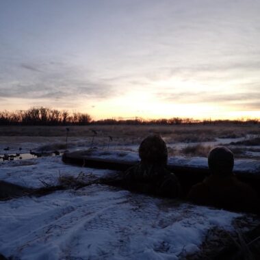 Hunters watching sunrise from waterfowl blind. Photo by Daryl Bauer, Nebraska Game & Parks Commission.