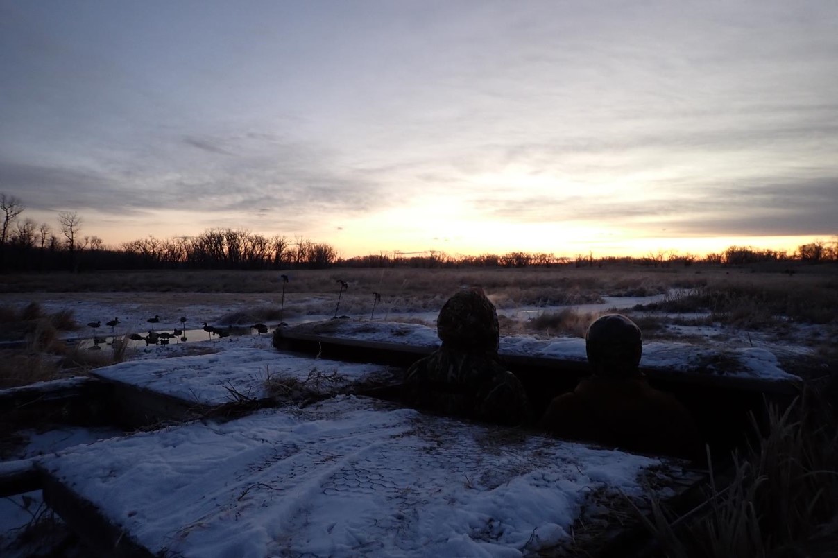 Hunters watching sunrise from waterfowl blind. Photo by Daryl Bauer, Nebraska Game & Parks Commission.