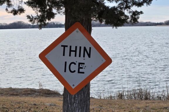 Thin Ice sign on lake shore. Photo by Daryl Bauer, Nebraska Game & Parks Commission.