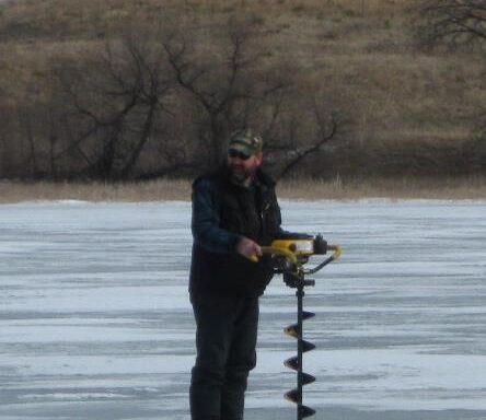 Angler drilling hole in ice. Don Cox photo.