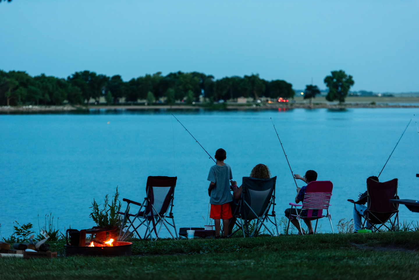 A family fishes from the bank near their campsite in the Lakeview Campground.