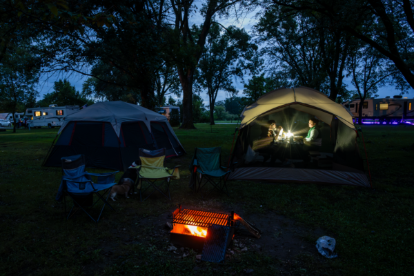 Amanda, Joshua and Victoria Walls of Omaha enjoy dinner by lantern light in their screen tent in the Area 3 campground.