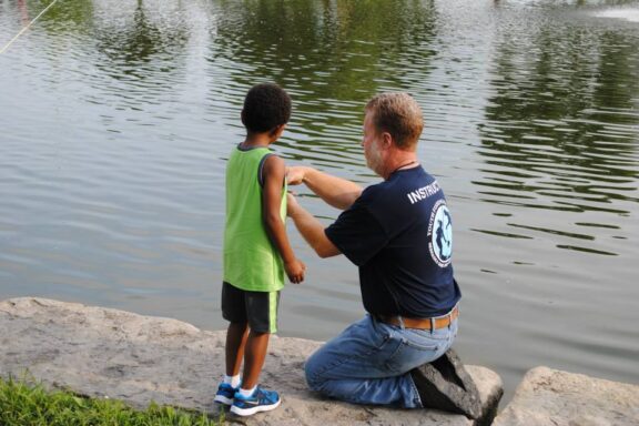 Nebraska Youth Fishing Instructor assisting a young angler. Photo by Nebraska Game & Parks Commission.