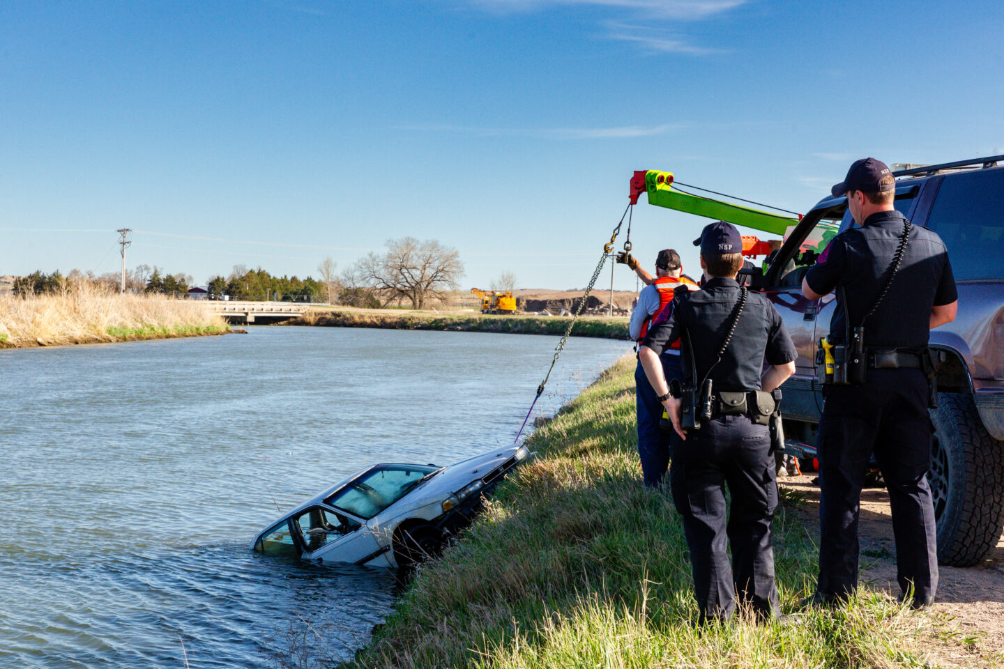 Lincoln County. Side sonar. Conservation officers Alex Hasenauer and Brandon O'Neal aided the Nebraska State Patrol in locating a vehicle that was put in the canal east of North Platte. NSP officers watch as the car is pulled from the canal. Geiser, April 29, 2020. Copyright NEBRASKAland Magazine, Nebraska Game and Parks Commission.