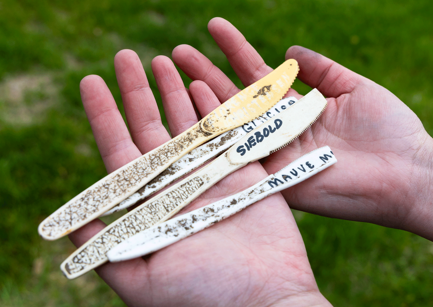 hands hold knives with blast marker words on them