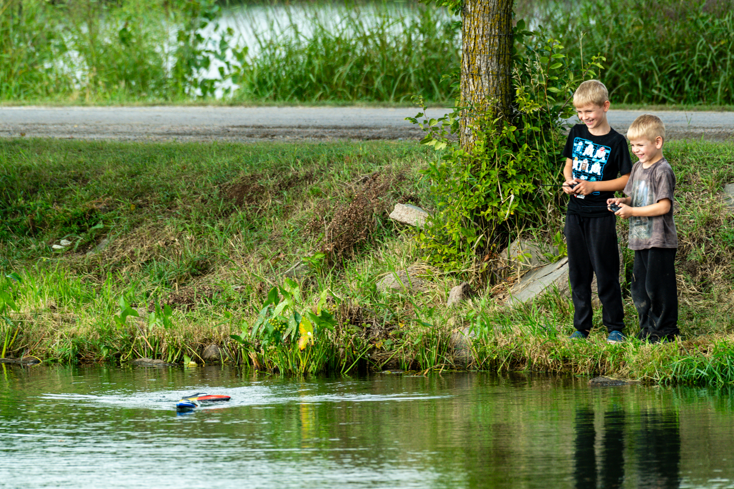 Layne and Dalton Wolfe of Tobias play with their remote-control boats on Lake 2.