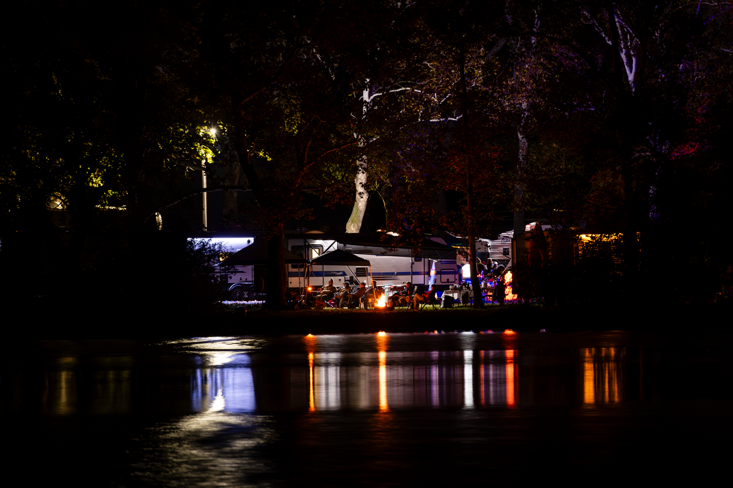 The glow of a lakeside campsite is reflected in Lake 2.