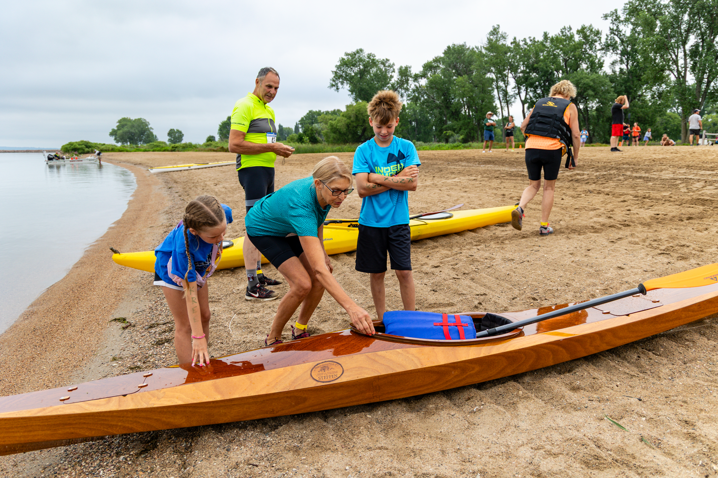 Crofton locals Jeff and Jolene Steffen showing their handcrafted kayak to curious children.