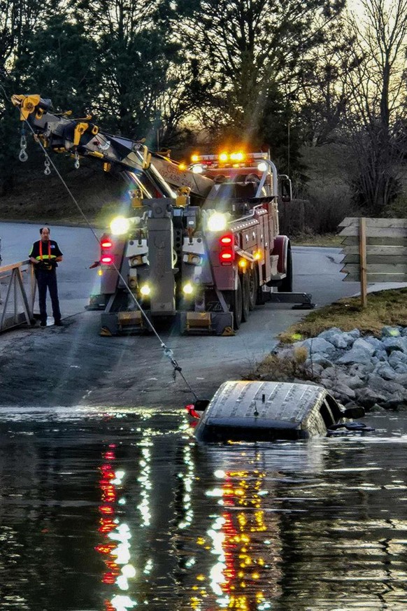 Tow truck pulling vehicle out of water.